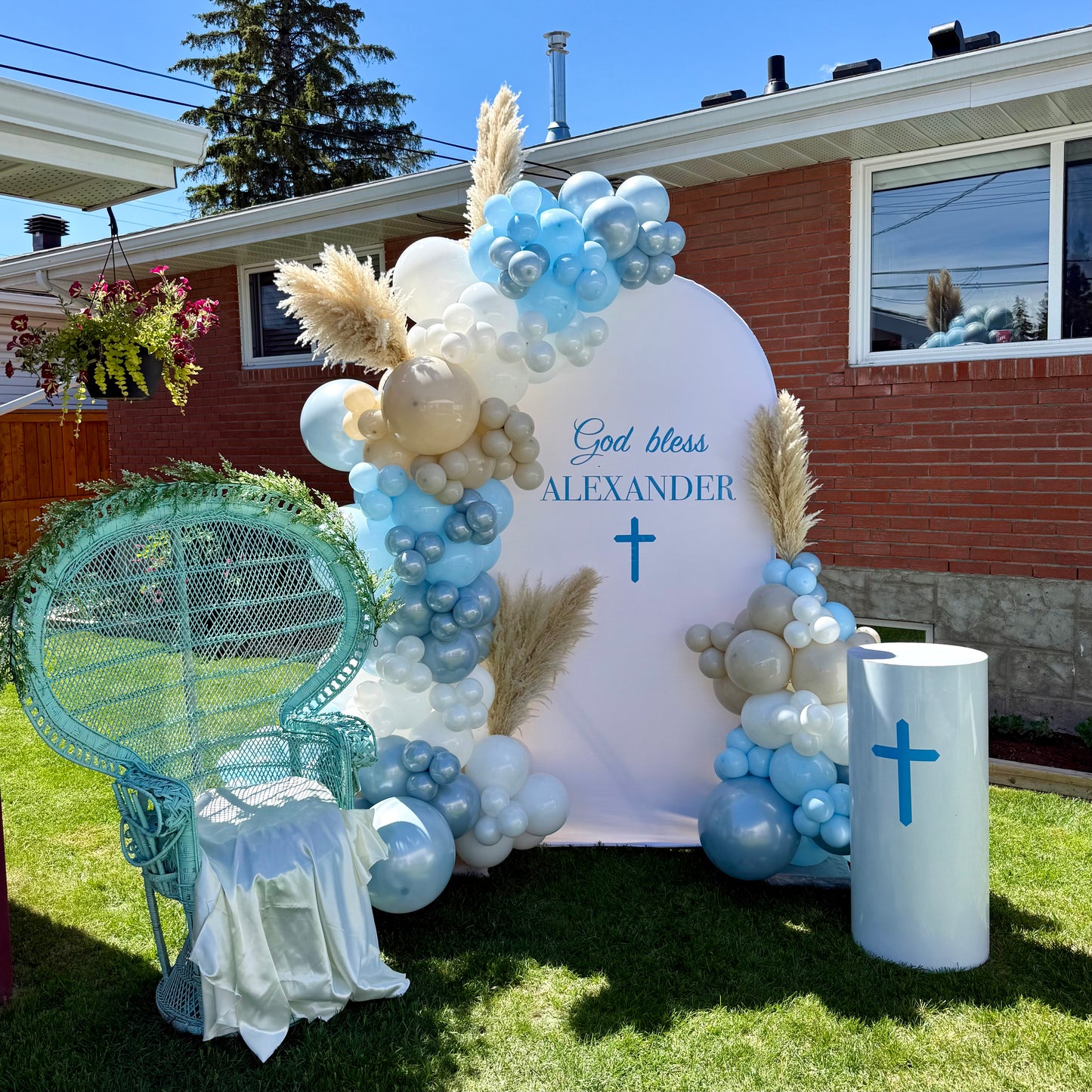 Boho christening backdrop with large vinyl god bless sign and white display plinth Calgary event decor