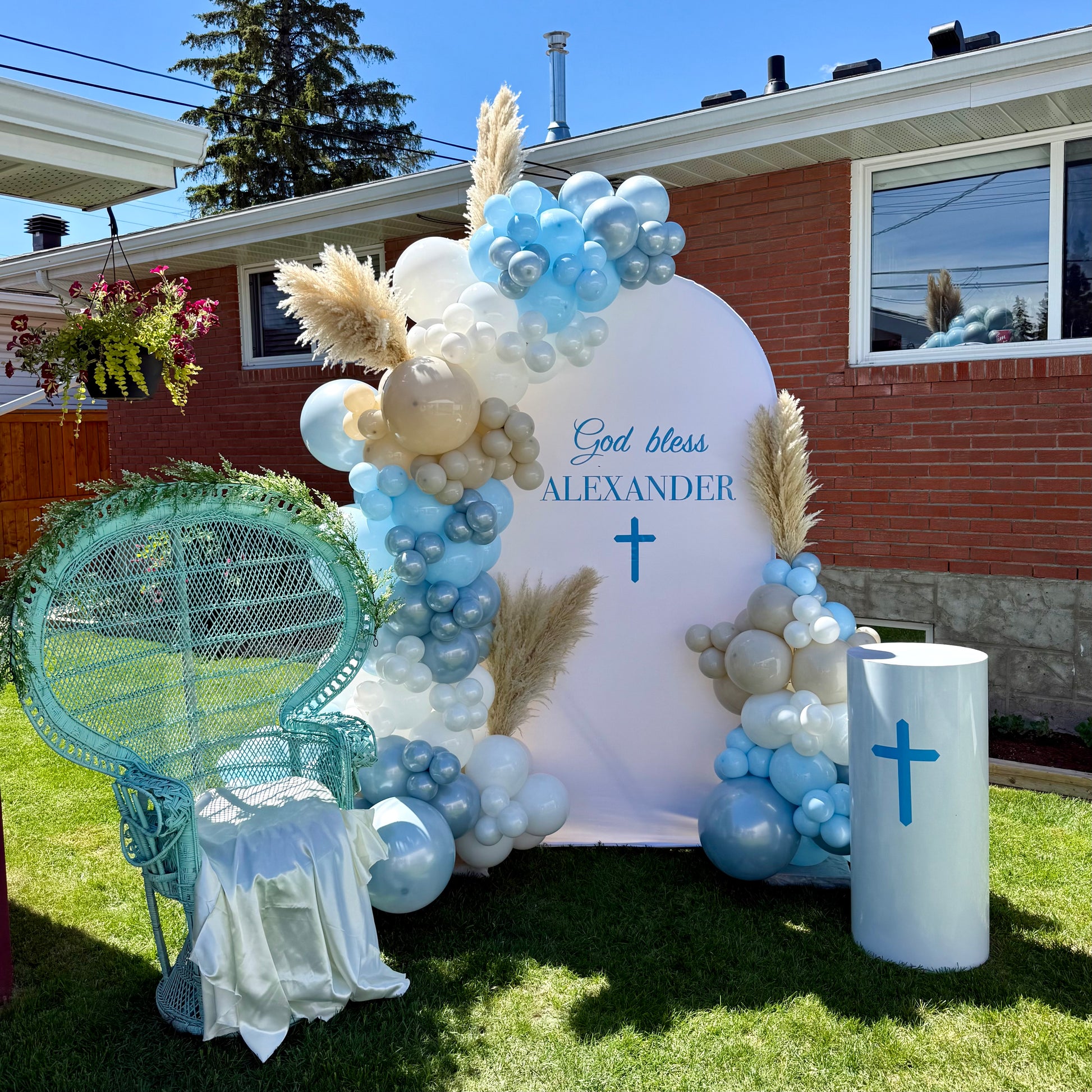 Boho christening backdrop with large vinyl god bless sign and white display plinth Calgary event decor