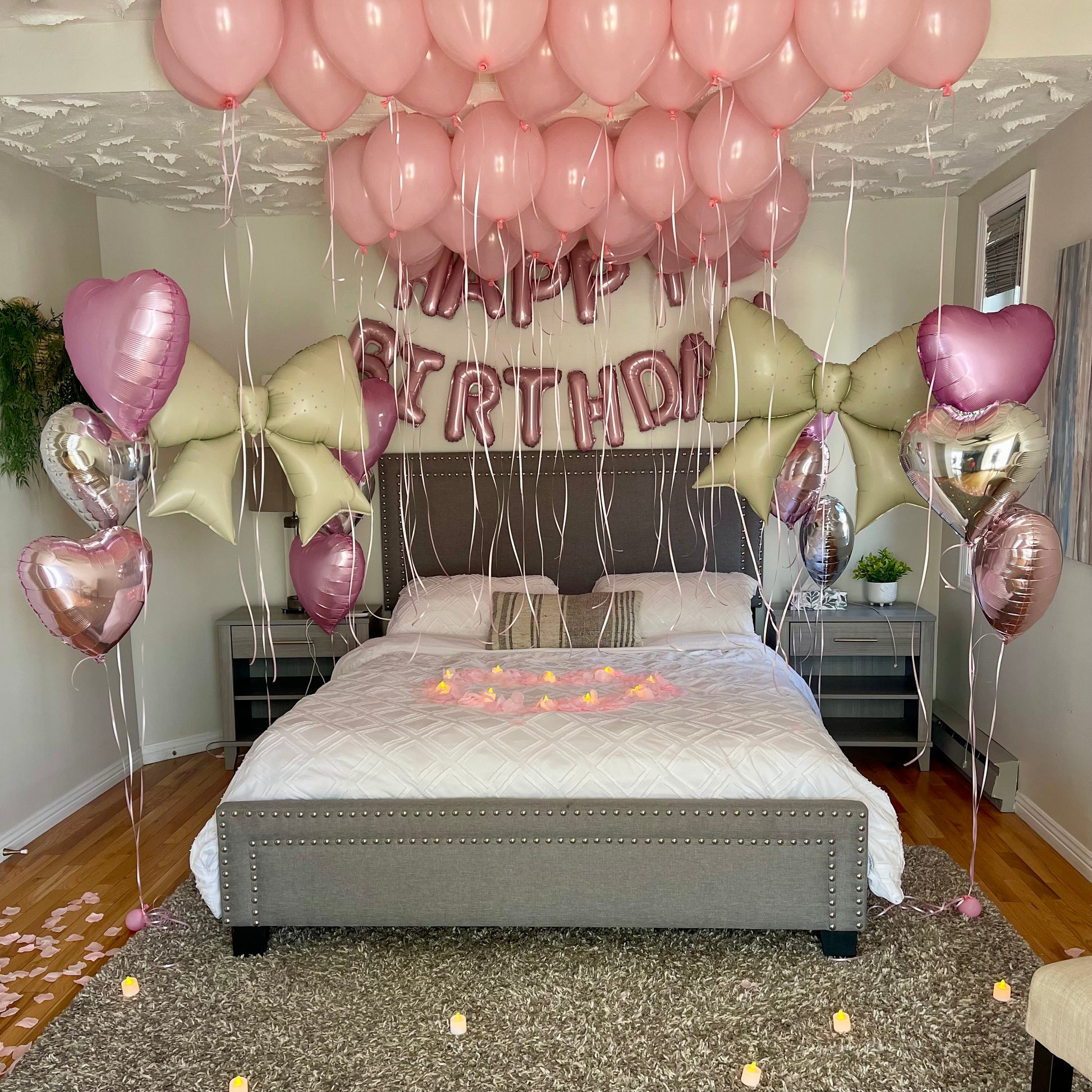 Decorated bedroom with balloons and 'Happy Birthday' banner over a bed.
