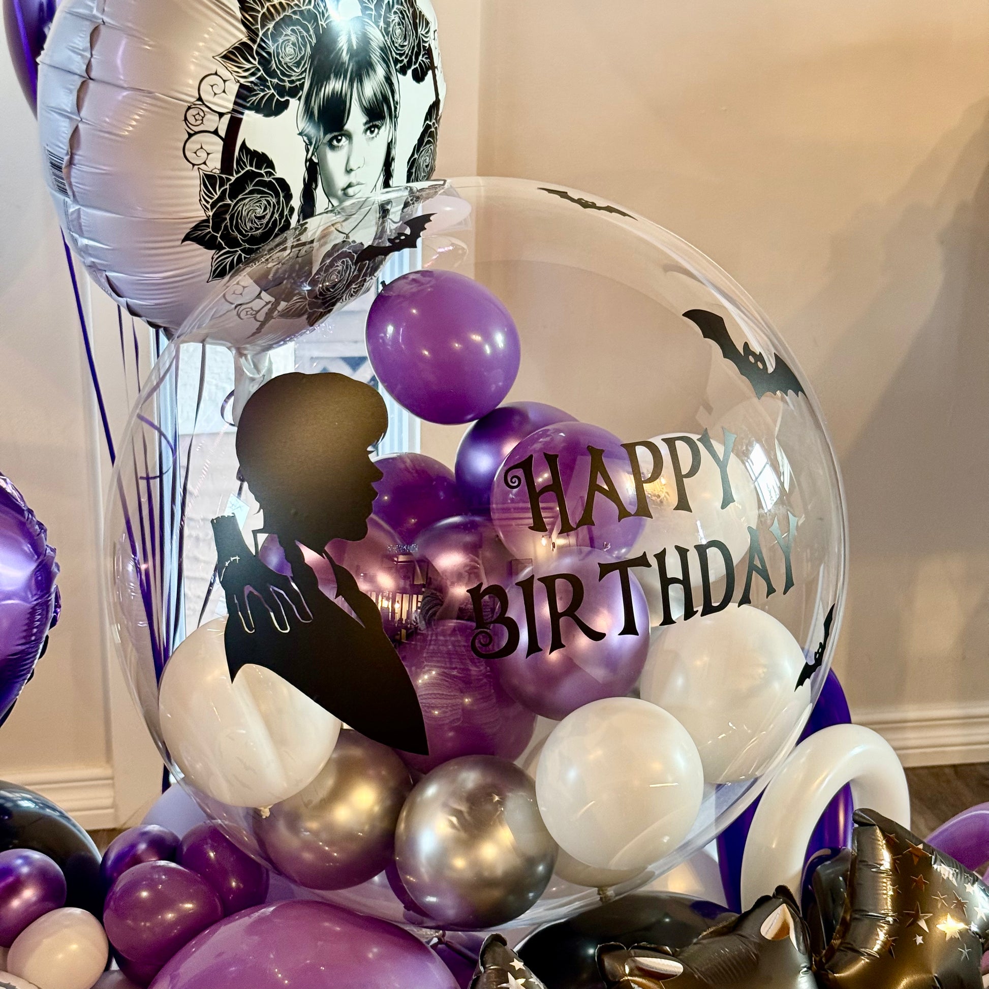 Clear bobo balloon with custom Wednesday vinyl silhouette and mini black latex inside Calgary party